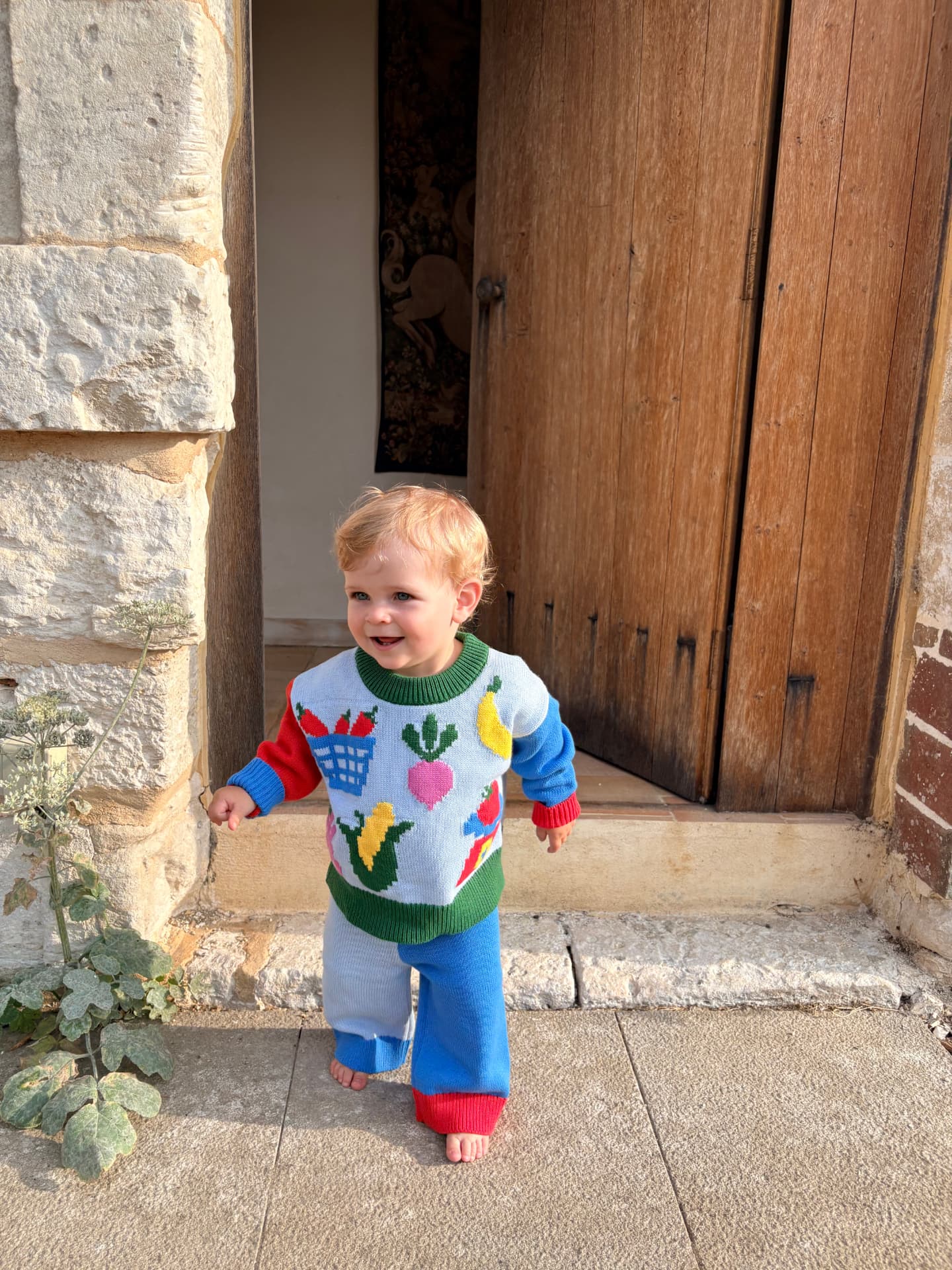 Little one in the Market Day set standing by a farmhouse door