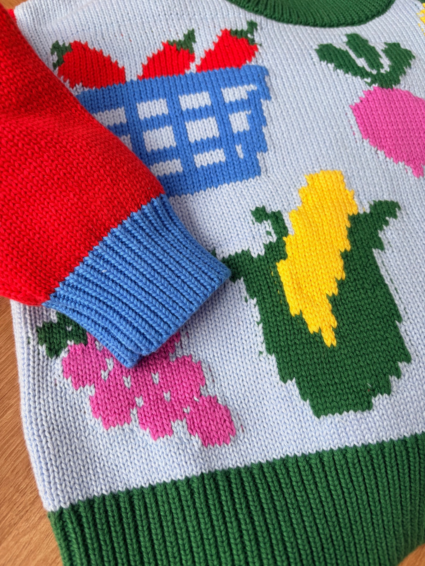 Close-up of the Market Day jumper sleeve and fruit and vegetable motifs